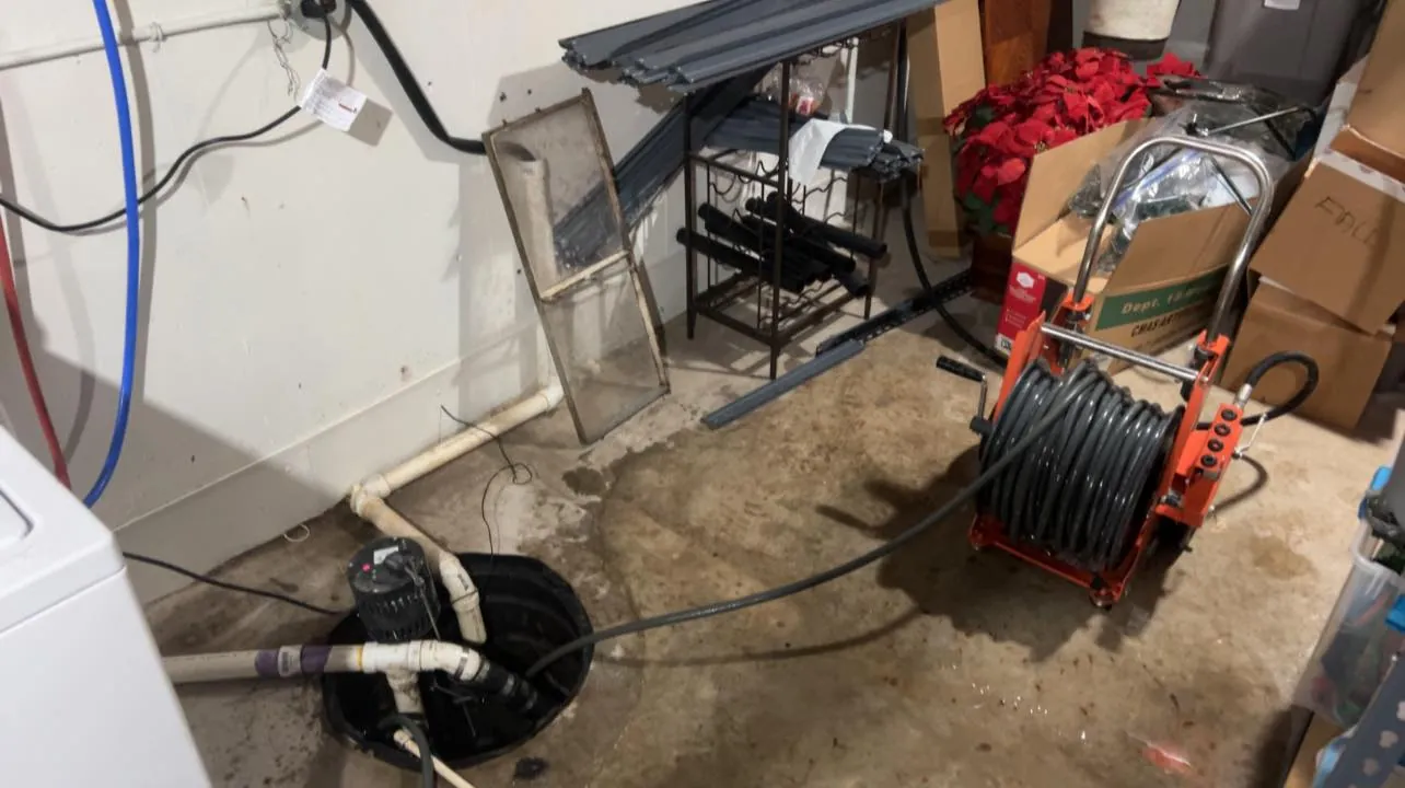 Drain cleaning reel set up beside a basement floor drain
